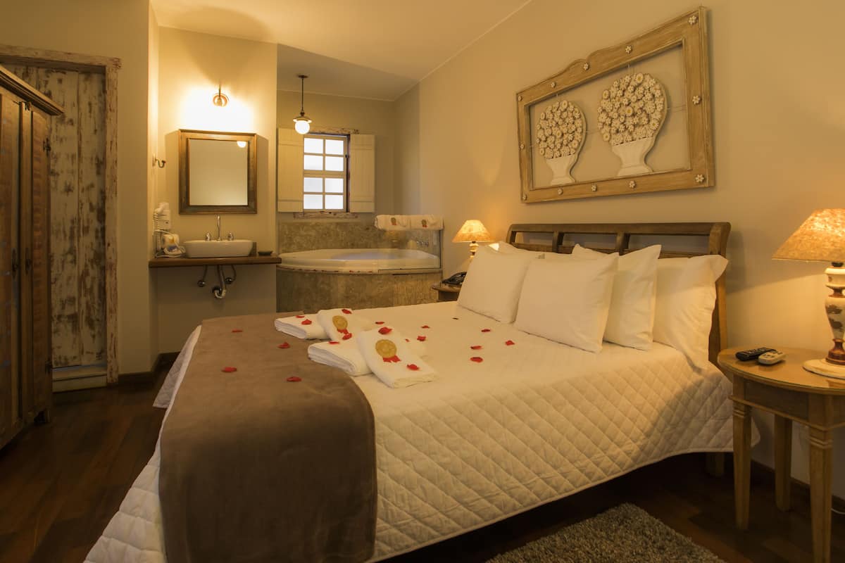 Ein Hotelzimmer mit Bett, Badewanne, Waschbecken und Spiegel.