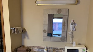 A compact kitchenette with a sink, microwave, and a small refrigerator. - Blue Spruce Motel (North Platte)