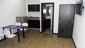 A compact living space with a dining area, kitchenette, and a door leading to another room. - Apartamento Quinta Paredes 036 (Bogotá)