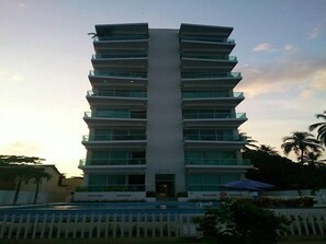 A multi-story hotel with a central entrance and balconies on each floor.