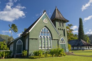 Eine grüne Kirche mit einem Spitzdach und großen Fenstern.