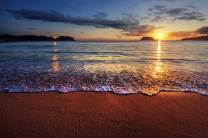 A beach with waves at sunset.