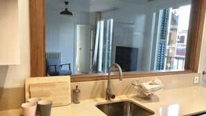 Uma cozinha moderna com uma janela grande, uma pia e uma máquina de lavar louça.