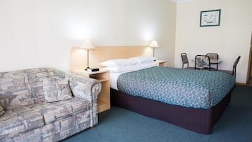 Een hotelkamer met een bed, een slaapbank, een bureau en een stoel.