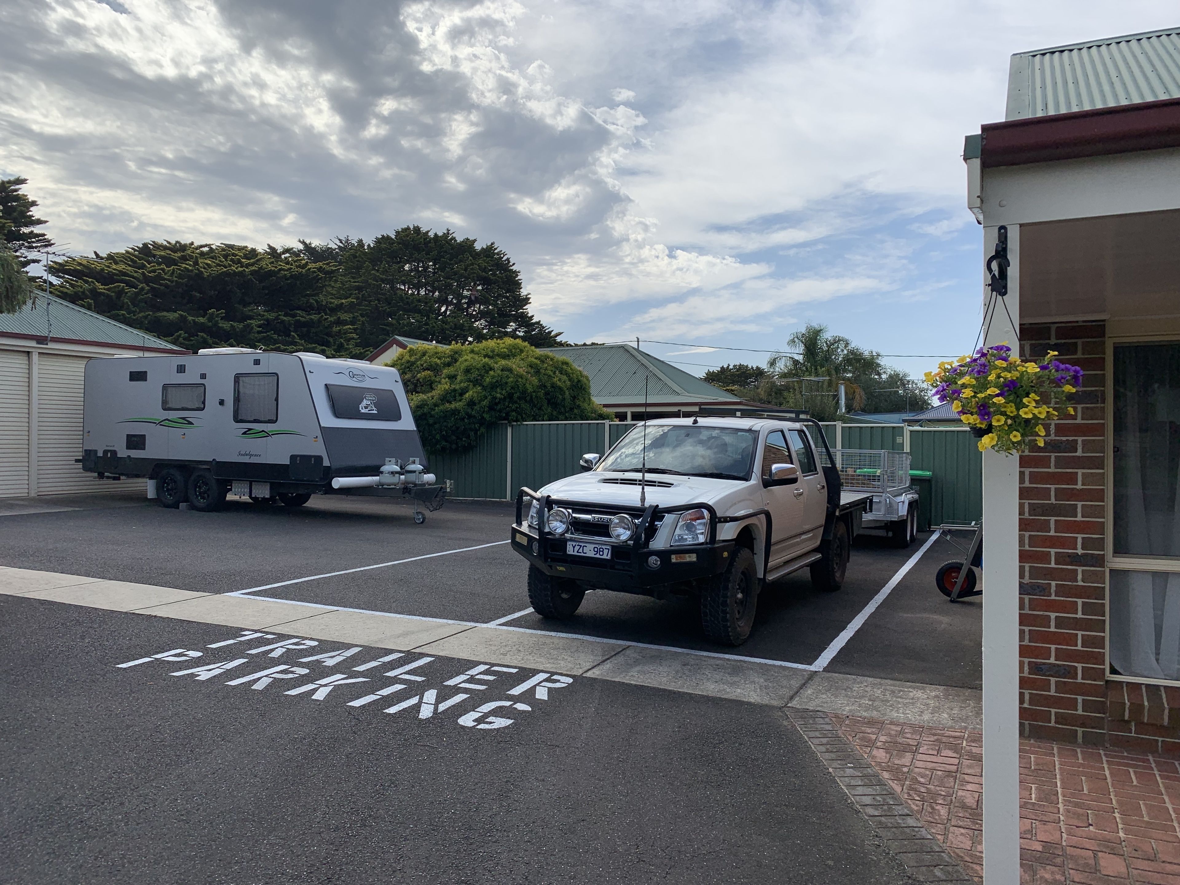 A parking area marked "TRAILER PARKING" with a camper trailer and a pickup truck.