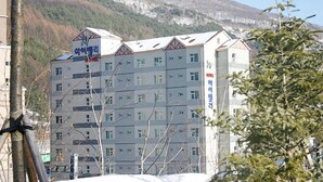 A multi-story hotel with a modern architectural design, featuring a prominent sign with Korean characters. - High Valley Hotel (Jeongseon)