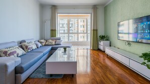 Ein modernes Wohnzimmer mit einer Couch, einem Couchtisch und einem Fernseher an der Wand.