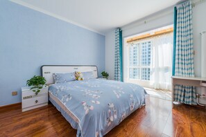 A bedroom with a bed, a nightstand, a dresser, a window with curtains, and a plant. - Bliss Guesthouse (Xi'an)