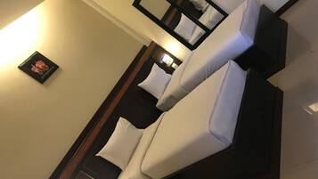 Una habitación de hotel moderna con una cama grande, un espejo y un cuadro en la pared.