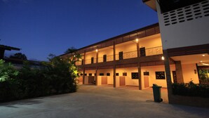 Edifício com vários andares, entrada coberta e varanda.
