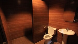 A bathroom with a toilet, sink, and mirror.