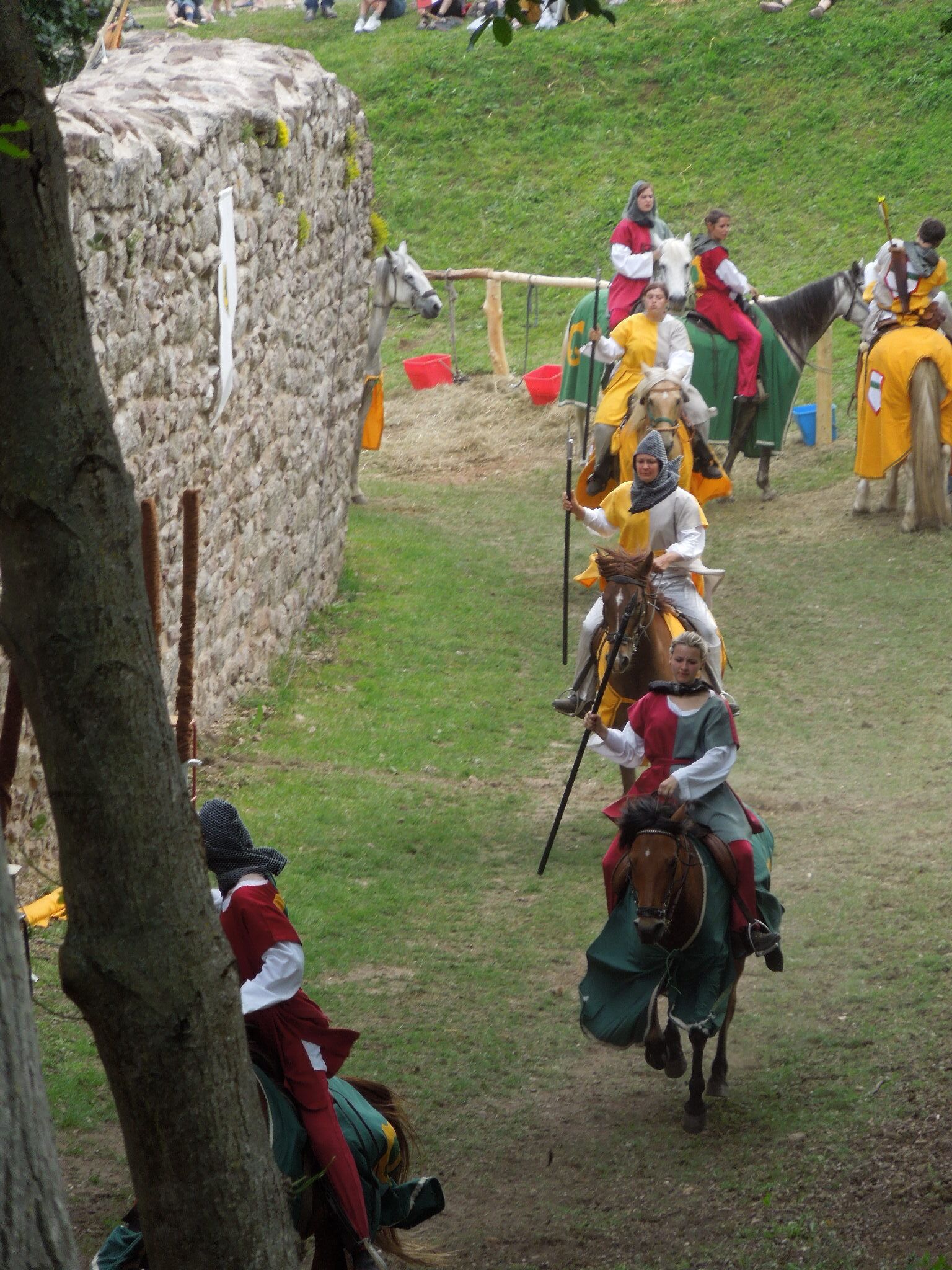 A historical reenactment with participants in medieval costumes on horseback.