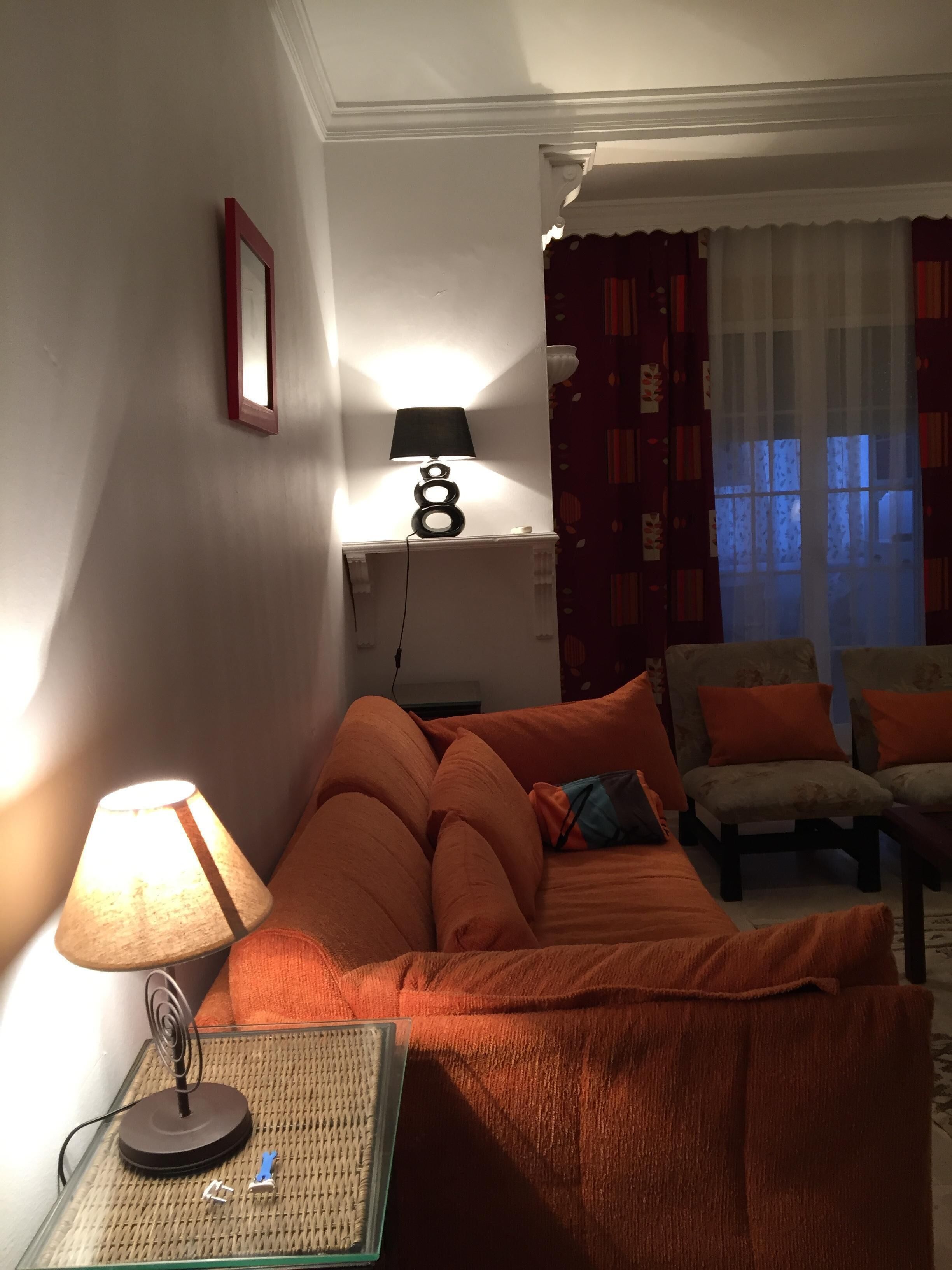 Ein gemütliches Zimmer mit einem Bett, einem Tisch mit einer Lampe und einem Stuhl.