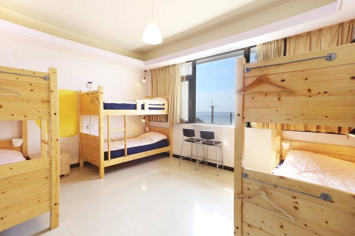 Una habitación con literas, un escritorio y una ventana con vistas.
