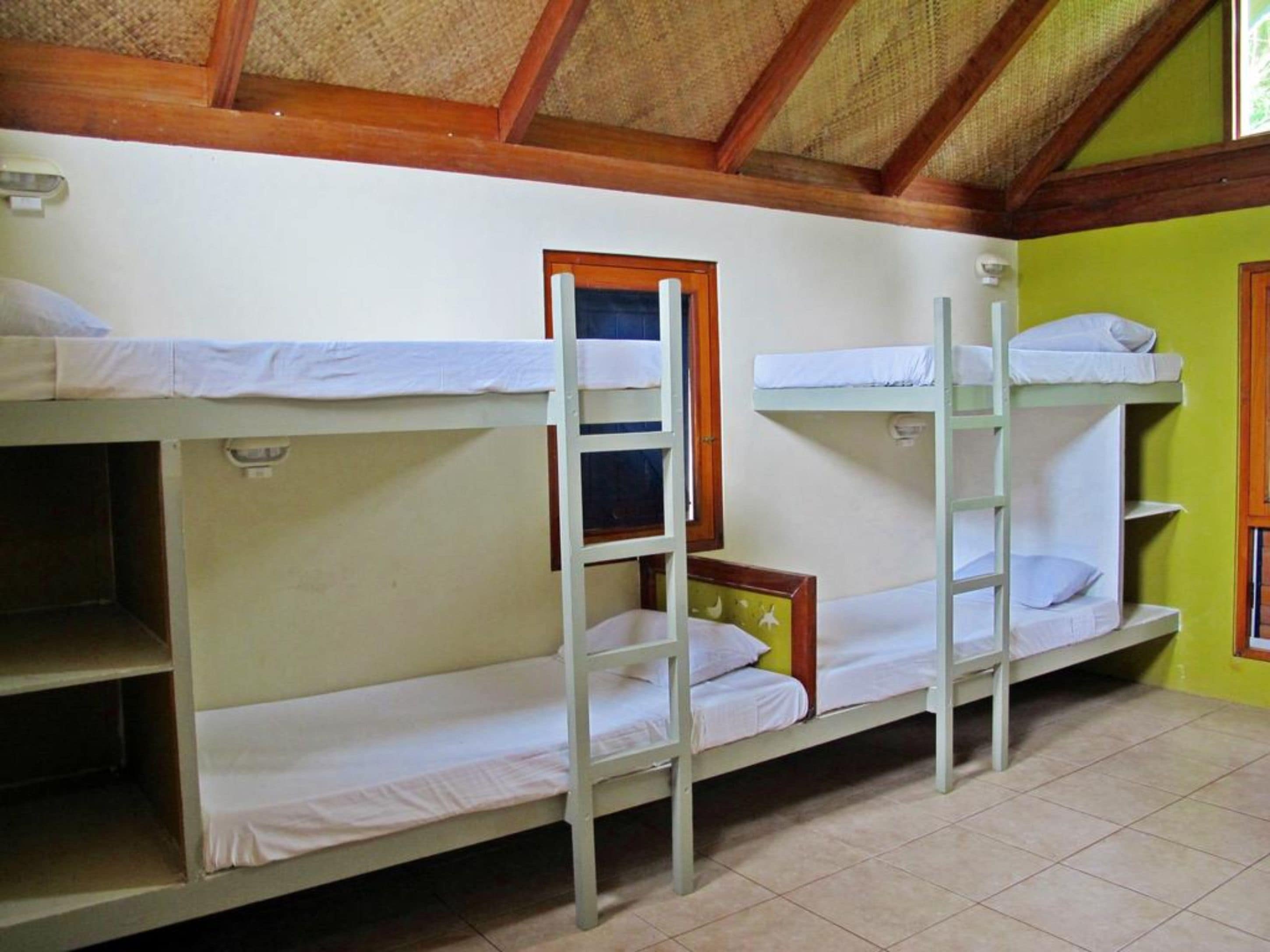 Bunk beds in a room with a tiled floor and a wooden ceiling.