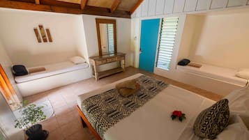 Un dormitorio con cama, un banco, un aparador y una puerta.