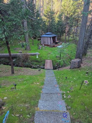 A forested area with a wooden deck leading to a cabin.