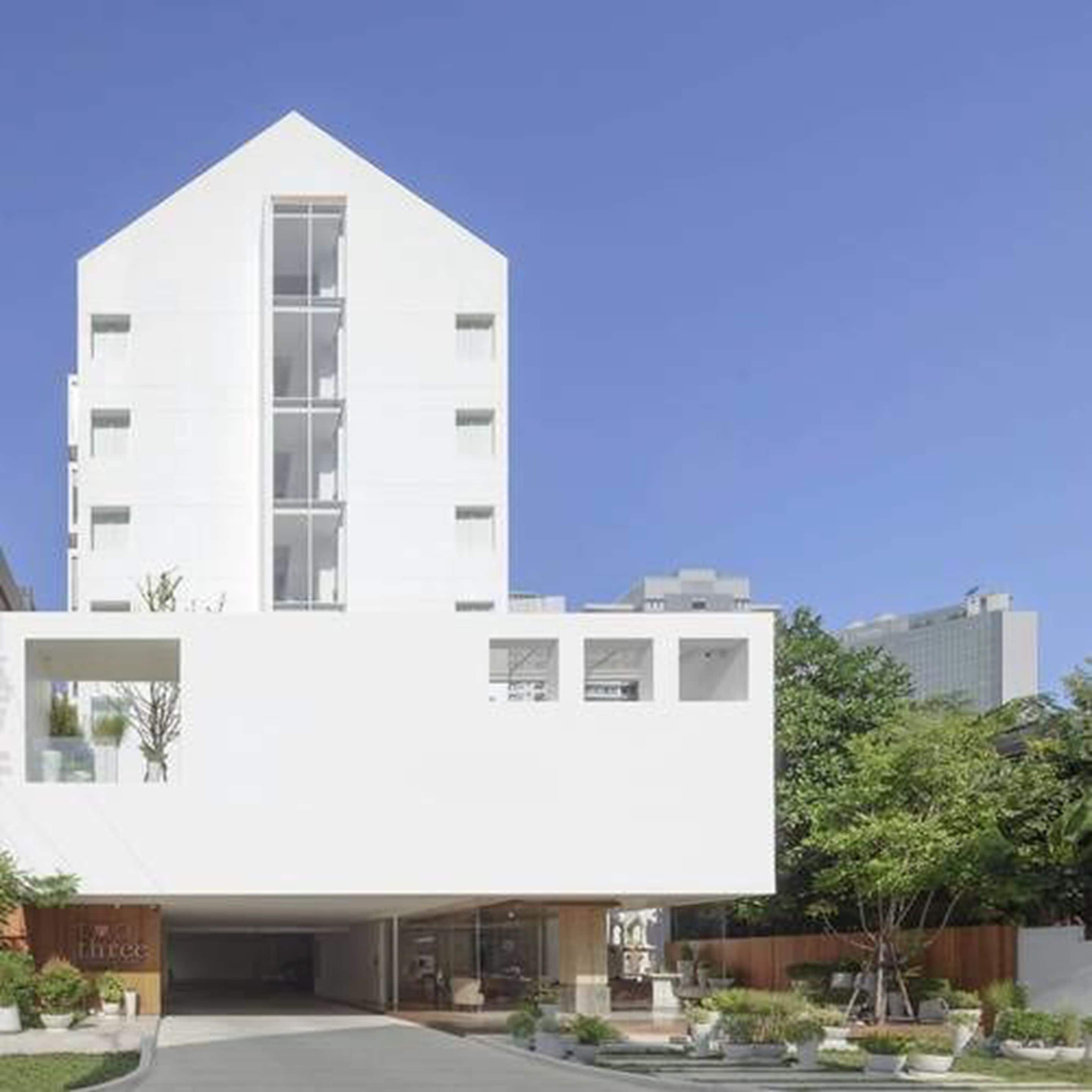 Un edificio moderno con techo plano, amplias ventanas y una entrada central.