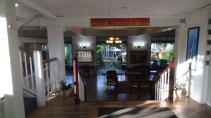 Un hall d’hôtel avec un plancher en bois, un comptoir d’accueil et un panneau indiquant les mesures de sécurité.