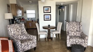 Una sala de estar con sillones estampados, una mesa redonda y un sofá.