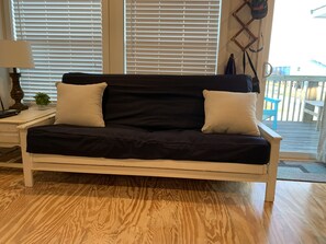 Relax in this inviting living room with a sofa, side table, and plant, offering a peaceful space to unwind.