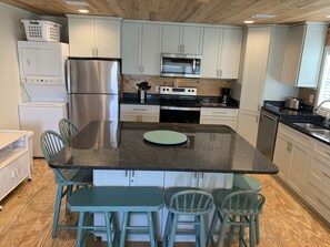Enjoy cooking in this well-equipped kitchen with a central island, stainless steel appliances, and ample seating for four.