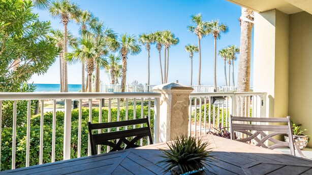 A balcony with a view of the ocean and palm trees. - BEACHFRONT GRAND PANAMA, 1st FLR DIRECT TO BEACH, PET-FRIENDLY. NEXT TO TIKI BAR (Panama City Beach)