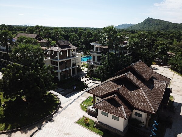Uma área residencial com casas modernas, piscina e montanha ao fundo.