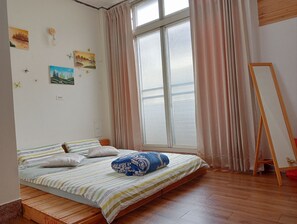 A bedroom with a bed, curtains, a window, and wall decorations. - Lawa House - Hostel (Chiayi City)