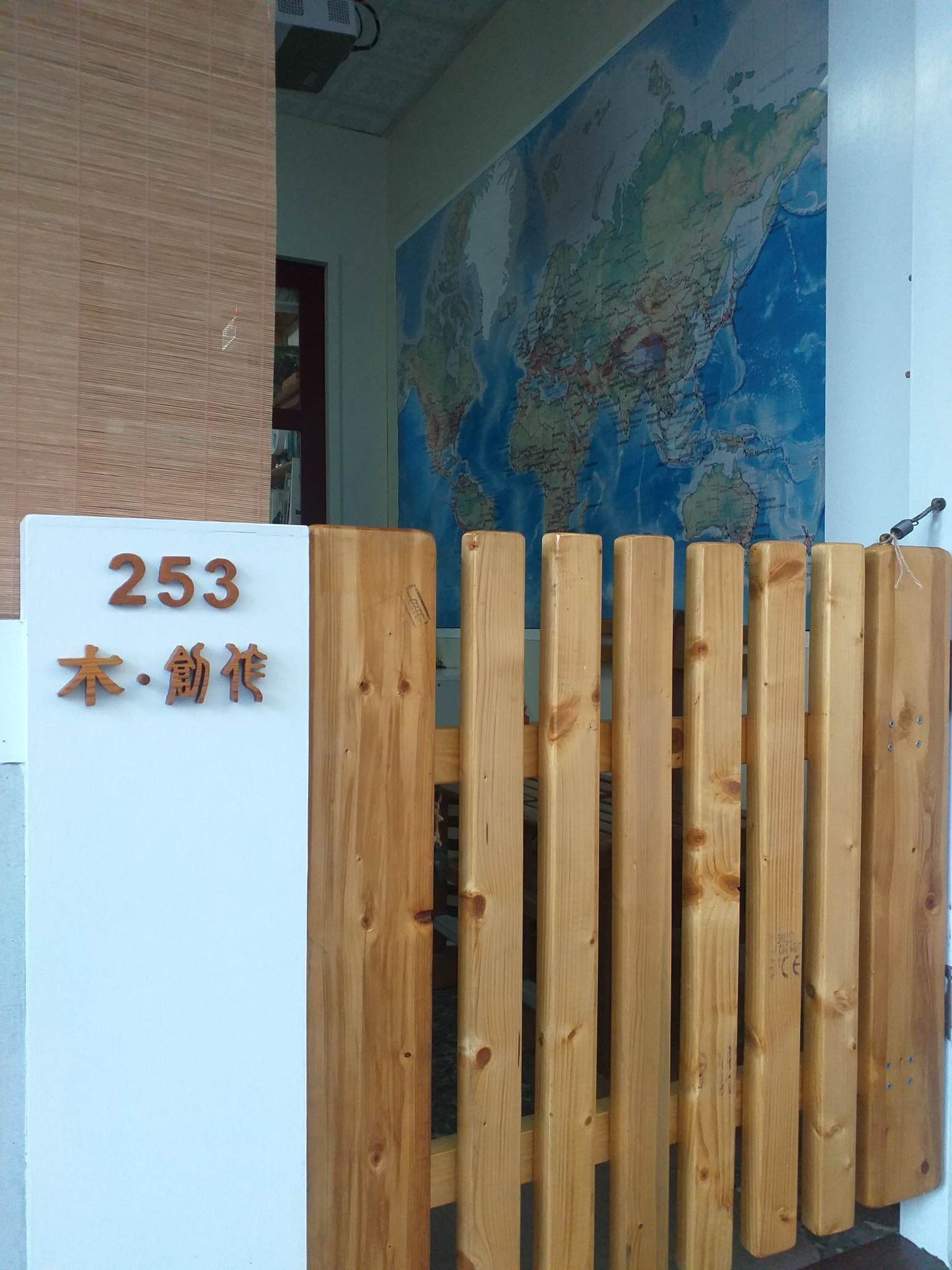A wooden gate with a sign displaying the number 253 and Japanese characters.