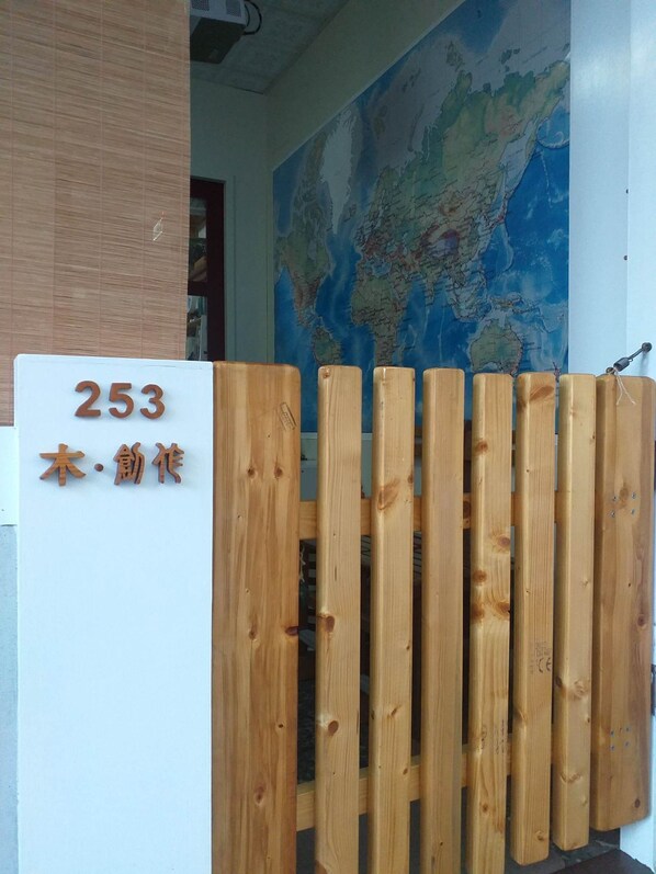 A wooden gate with a sign displaying the number 253 and Japanese characters.