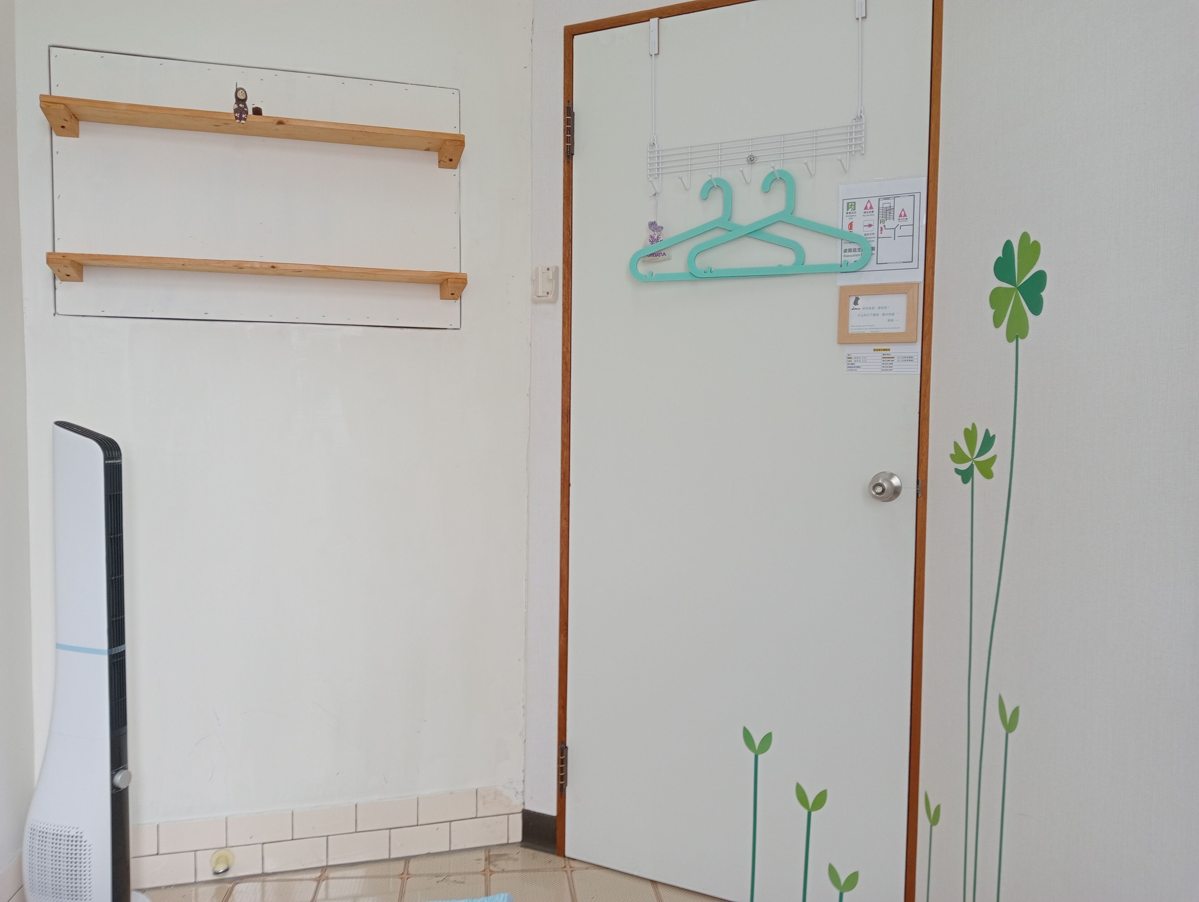 A room with a white door, wooden shelves, a wall-mounted drying rack, and a radiator.