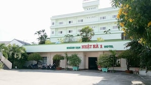 A hotel with a sign reading "KHÃCH SAN NHÃT HÃ 1 HOTEL" and a parking area in front. - Nhat Ha Hotel (Can Tho)