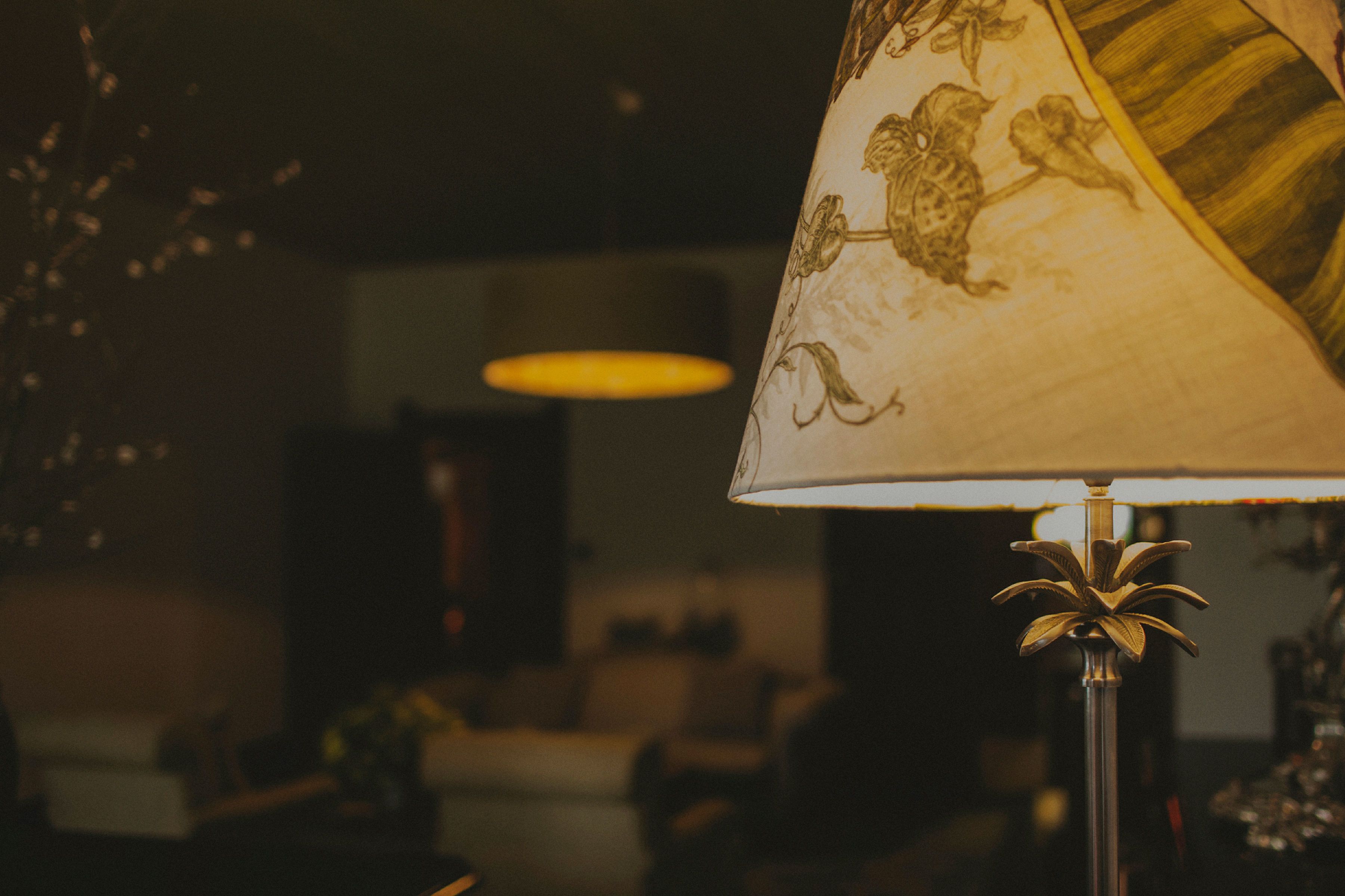 A lamp with a floral design in a dimly lit room.