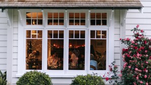 A white building with a large window displaying people dining inside. - Wallingford Homestead (Wallingford)