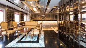 Un vestíbulo lujoso con suelo de mármol, muebles elegantes y un diseño de techo moderno.