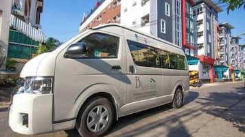 Una camioneta blanca estacionada en una calle con edificios al fondo.