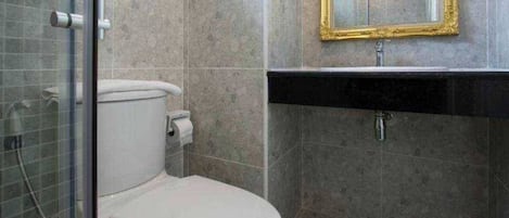 Une salle de bain avec des toilettes, un lavabo et un miroir.