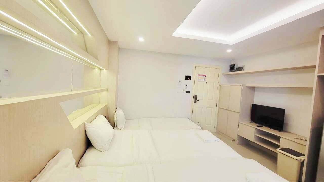 A hotel room with a bed, a TV, a desk, and a wardrobe.
