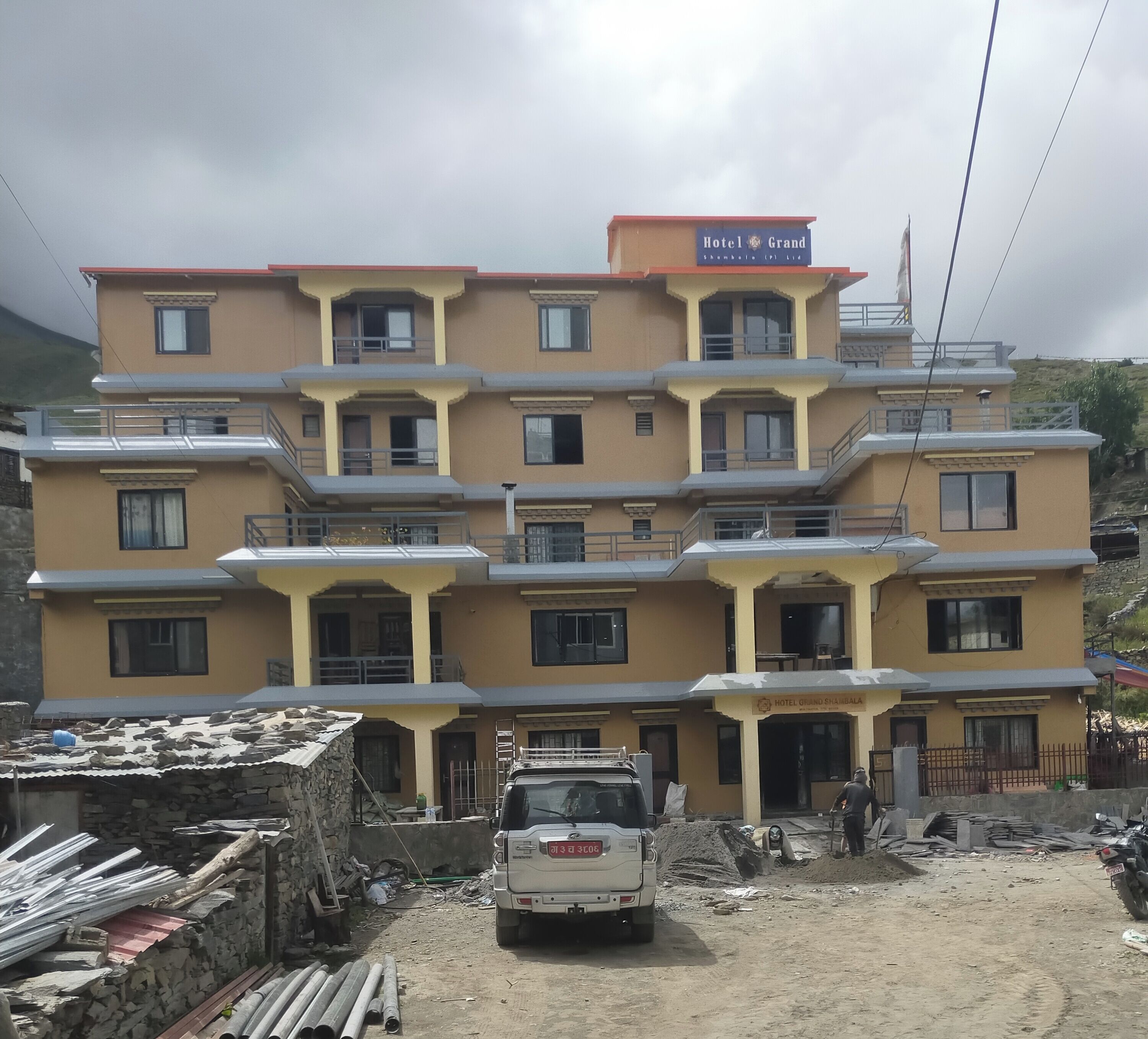 A multi-story hotel with balconies and a sign that reads "Hotel Grand".