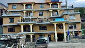 A multi-story hotel with balconies and a sign reading "Hotel Grand Shambala". - Hotel Grand Shambala (Muktinath)