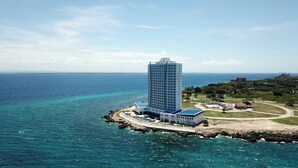 A high-rise hotel with a view of the ocean and a beach. - Arterra Hotel and Resort (Lapu-Lapu)