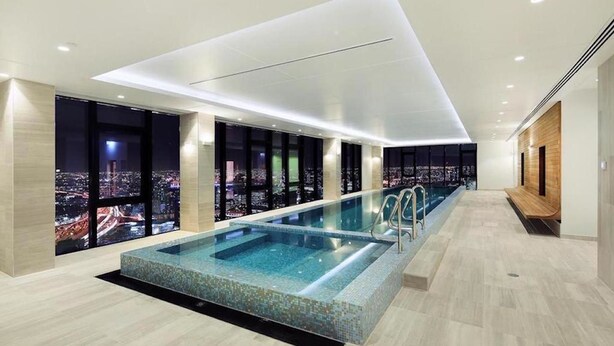 Ein modernes Hallenbad mit Blick auf die Stadt, gekennzeichnet durch ein elegantes Design und eine lange, schmale Form.