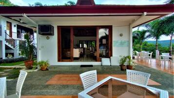 A restaurant with outdoor seating, a covered patio, and a view of the landscape.