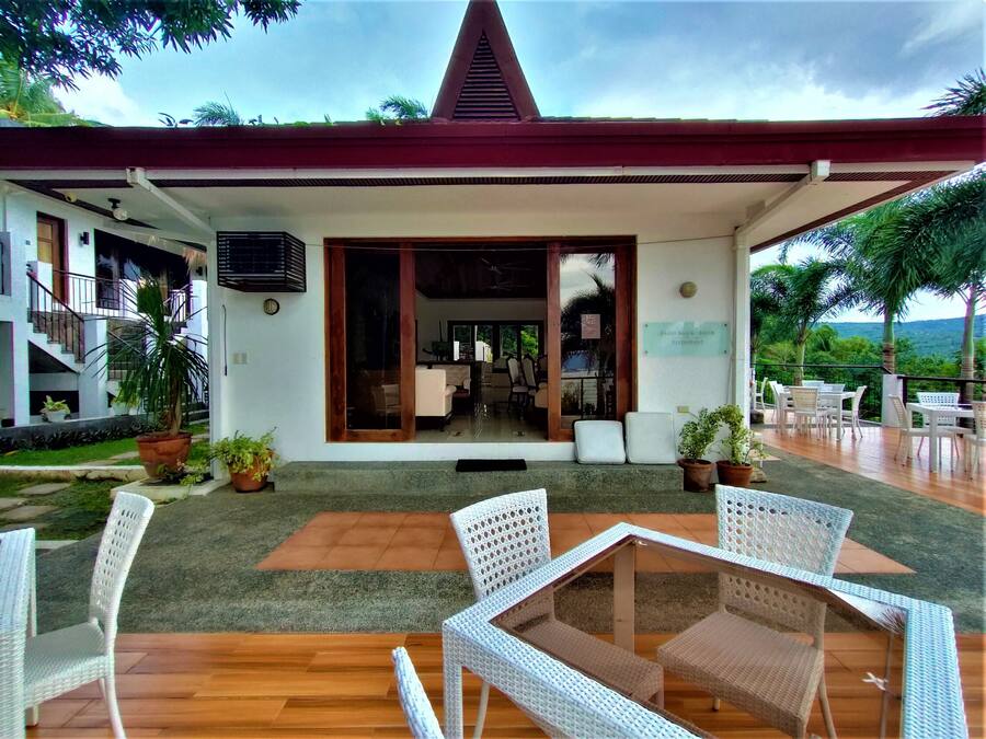 A restaurant with outdoor seating, a covered patio, and a view of the landscape.