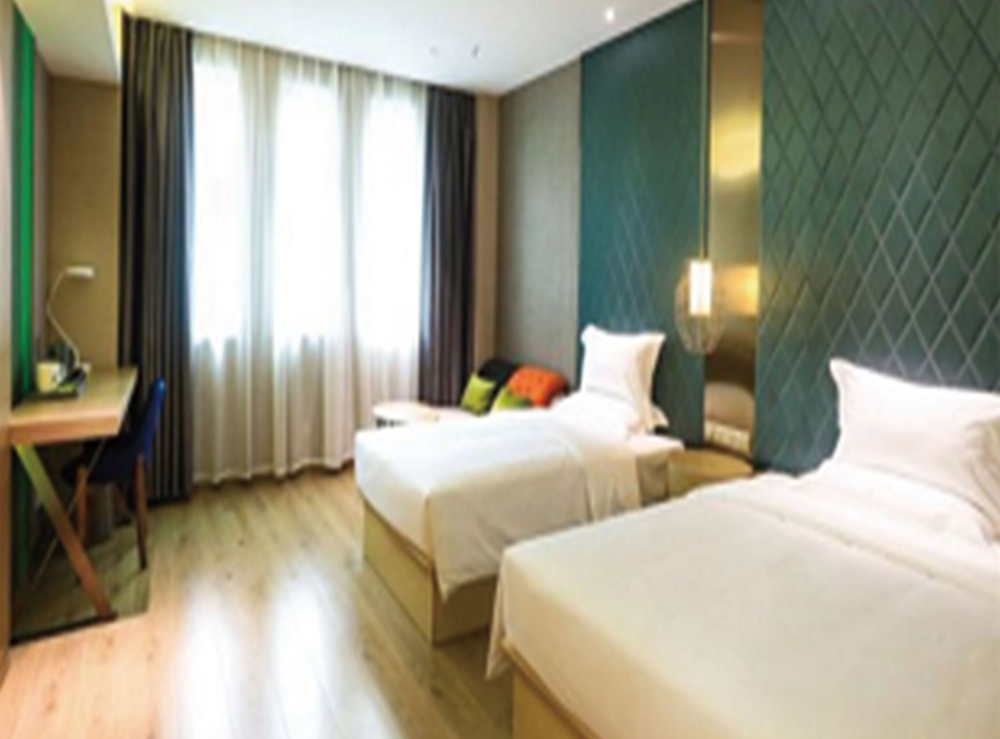 Une chambre d’hôtel avec deux lits, un bureau et une chaise.