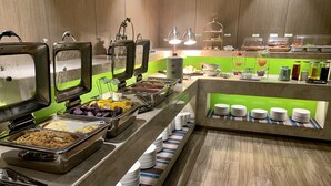 A buffet with various food options, including salads, fruits, and hot dishes. - ibis Styles XM Zhongshan (Xiamen)