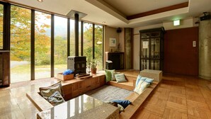 Un salón amplio con chimenea, ventanas grandes y vistas al exterior.