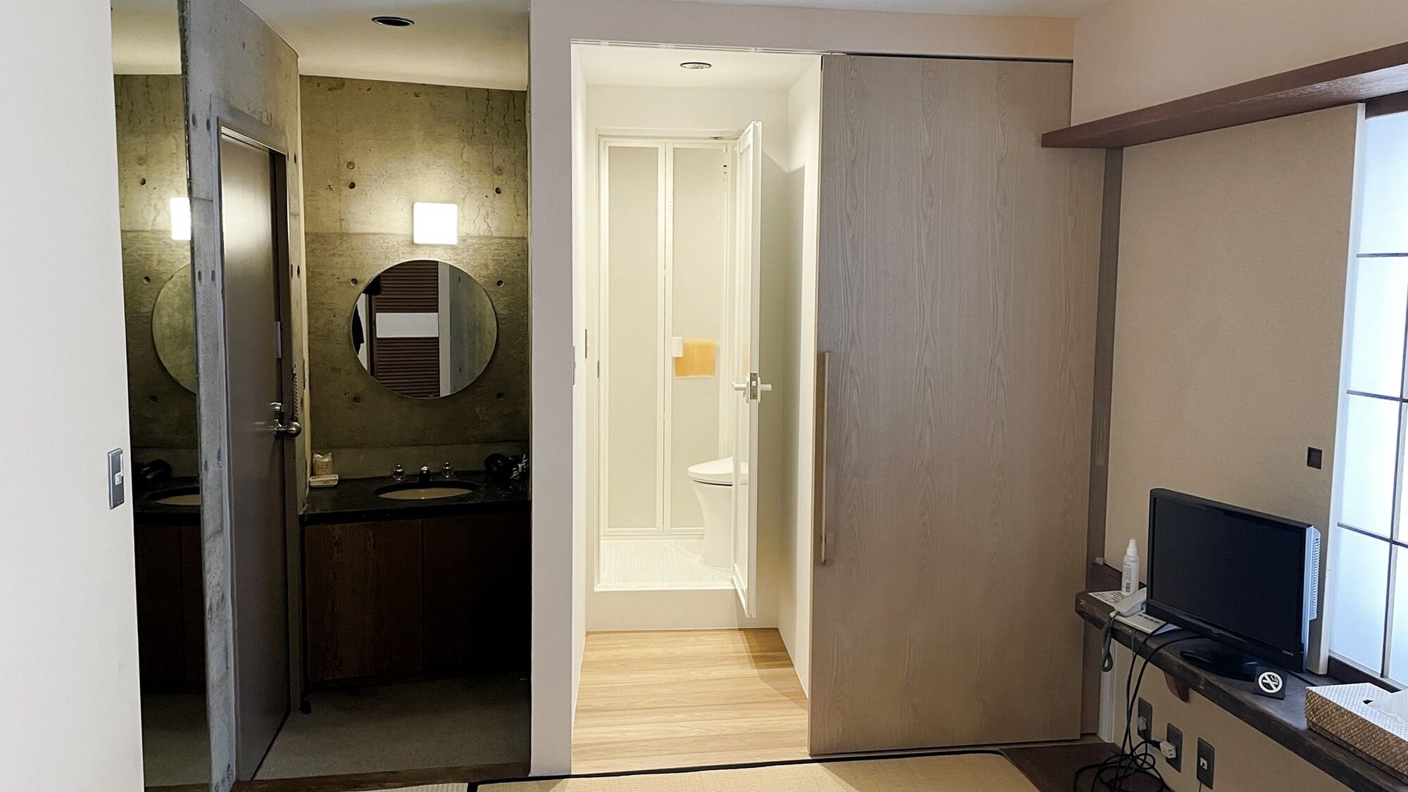 A modern bathroom with a sink, mirror, and toilet.