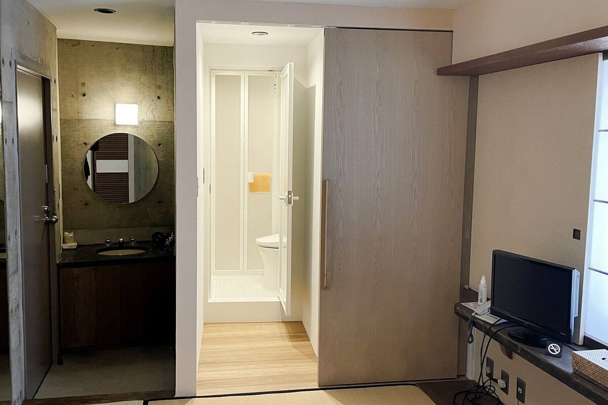 A modern bathroom with a sink, mirror, and toilet.